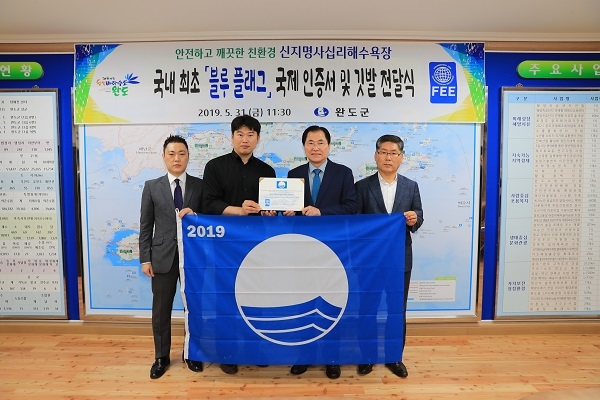 ▲완도군은 블루플래그(BLUE FLAG) 인증서 및 깃발을 환경교육재단(FEE) 국내 본부로부터 전달받았다.(사진제공=완도군)