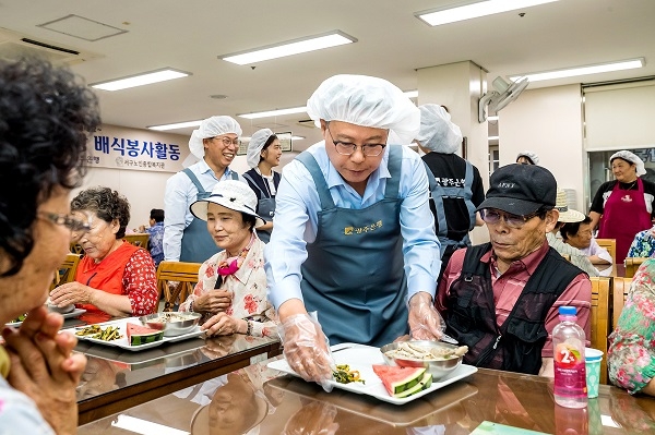 ▲송종욱 광주은행장이 서구노인종합복지관에서는 삼계탕을 배식하고 있다.(사진제공=광주은행)