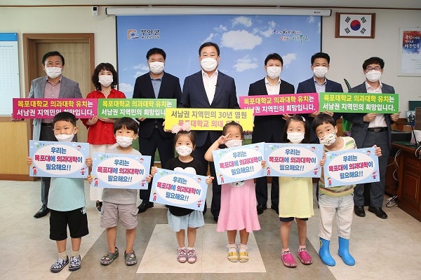 ▲김산 무안군수와 공직자들은 31일 목포대 의과대학 유치를 기원하는 릴레이 캠페인에 참여했다.(사진제공=무안군)