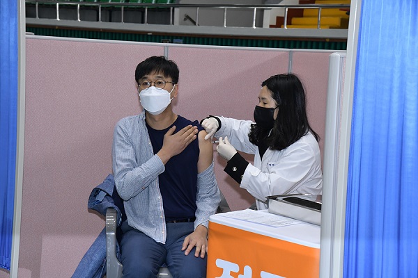 ▲백신 접종 첫 날인 2월 26일 오전 여수시 코로나19 예방접종센터인 흥국체육관에서 전남에서 처음 접종을 맞은 요양병원 관계자가 아스트라제네카 백신 접종을 받고 있다.(사진제공=여수시)