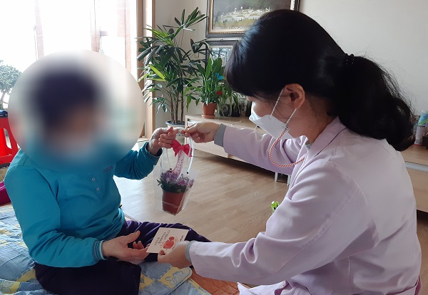 ▲독거치매어르신 가정을 방문해 사랑의 꽃 화분을 전달하는 모습(사진제공=함평군)