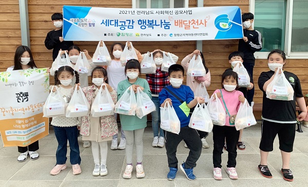 ▲행사에 참여한 지역아동센터 아이들이 준비한 선물 꾸러미를 들고 기념촬영을 하고 있다.(사진제공=함평군)
