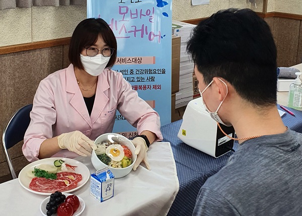 ▲모바일 헬스케어 참여자가 중간검진(영양상담)을 받고 있는 모습(사진제공=함평군)
