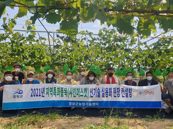 ▲영광군은 지난 21일 한 샤인머스켓 재배 농가에서 시설, 생장조절, 묘목 관리 등 교육을 받고 기념사진을 찍고 있다.(사진제공=영광군)
