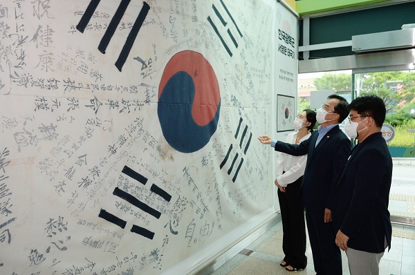 ▲김삼호 광산구청장이 13일 광산구청 1층에 전시된 ‘한국광복군 서명문 태극기’를 살펴보고 있다.(사진제공=광산구)