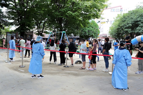 ▲지난 4일 광산구가 외국인 밀집지역인 월곡동 다모아어린이공원에 마련한 임시 선별진료소에서 검사를 받으려는 시민들이 줄을 서 기다리고 있는 모습(사진제공=광산구)