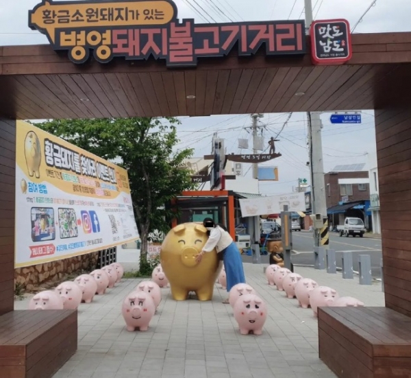 ▲ 5월 병영돼지불고기거리 방문의 달에 추진한 ‘황금돼지를 찾아라 인증샷 이벤트’에 참여하고 있는 방문객의 모습(사진제공=강진군)