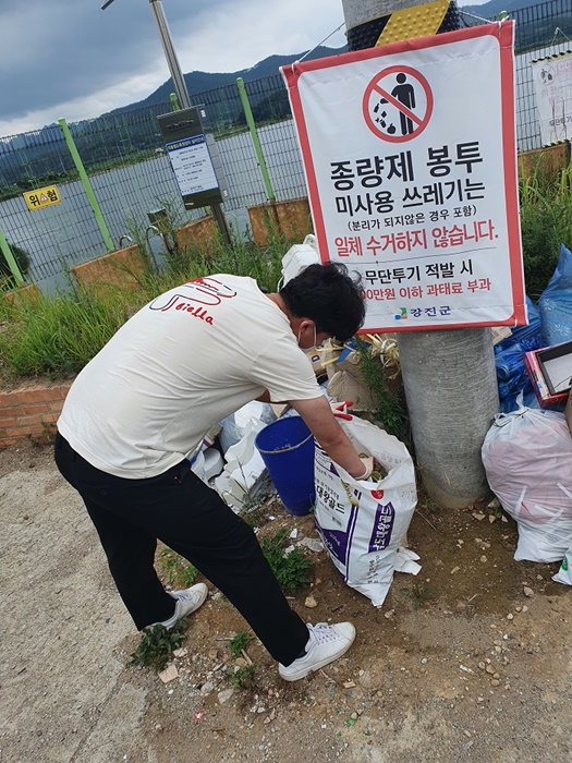 ▲단속반이 무단 투기된 쓰레기를 확인하고 있다.(사진제공=강진군)