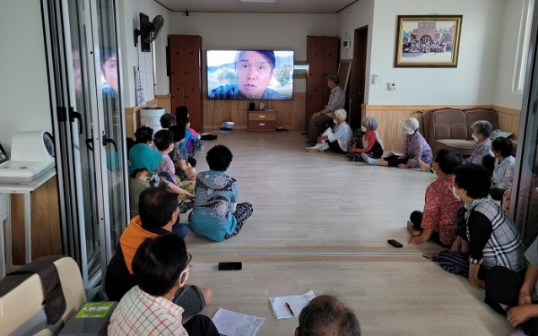 ▲문덕면 법화마을회관에 모인 교육 대상자들이 공익직불제 의무교육을 영상을 통해 시청하고 있다.(사진제공=보성군)