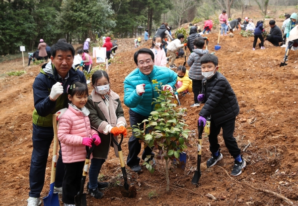 ▲관내 주민 등 400여 명이 보은산 일원에서 식목일 기념 동백나무를 심고 있다.(사진제공=강진군)