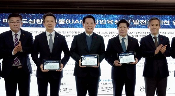 김영록 전남도지사가 지난 2022년 12월 5일 고흥 드론 특화지식산업센터 개소식에서 도심항공교통(UAM) 신사업 분야 서비스모델 발굴을 위해 고흥군(군수 공영민), ㈜대우건설(대표 백정완)과 업무협약을 하는 모습.(사진제공=전라남도)