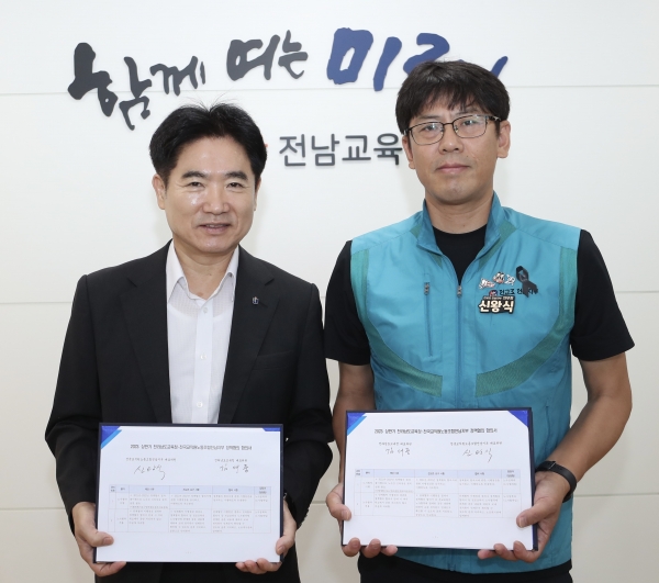 ▲김대중 전남교육감(왼쪽)과 신왕식 전교조전남지부장이 합의서에 서명한 뒤 들어보이고 있다.(사진제공=전라남도교육청)