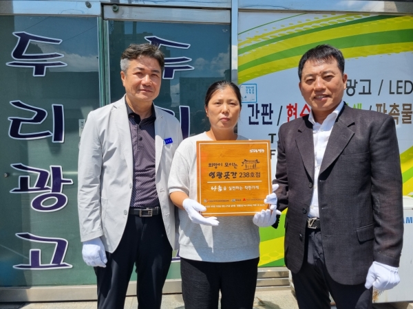 ▲영광군은 지난 18일 영광읍 현암길에 위치한 두리광고LED에 영광곳간 ‘나눔을 실천하는 착한가게’238호점 현판을 전달했다.(사진제공=영광군)