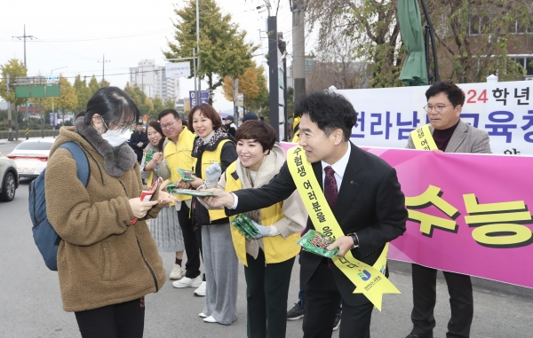 ▲김대중 전남교육감이 수험생에게 핫팩을 전달하며 격려하고 있다.(사진제공=전라남도교육청)