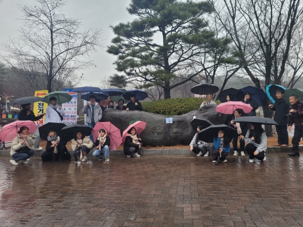 ▲학생들이 비가 오는 날씨 속에서도 우산을 받쳐 든 채 우포늪 생태에 대한 설명을 듣고 있다.(사진제공=전라남도교육청)