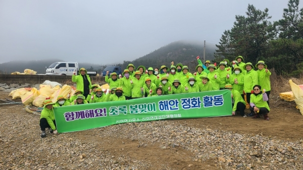 ▲지난 19일 신의면 상태서리 오리평지선에서 여성단체협의회원과 신의면 직원들이 해안 정화 활동 후 기념 촬영을 하고 있다.(사진제공=신안군)