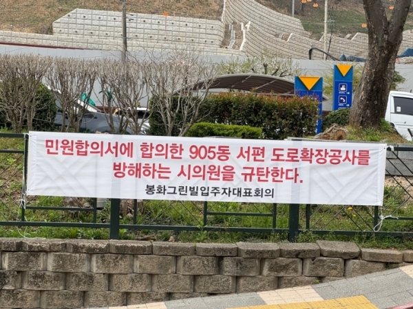 ▲순천시 조례동 봉화그린빌 아파트 입구에 금품수수 의혹을 받고 있는 순천시의원을 질타하는 현수막이 부착돼 있다.