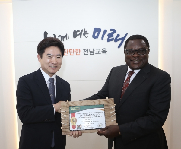 ▲케냐 붕고마 카운티의 루사카 케네스 마켈로 주지사(오른쪽)가 김대중 전남교육감(왼쪽)에게 감사패를 전달하며 악수하고 있다.(사진제공=전라남도교육청)