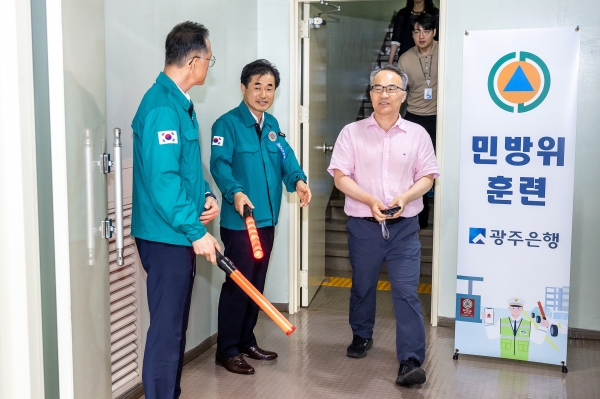▲신동하 광주 동구 부구청장과 임양진 광주은행 부행장의 유도에 따라 임직원들이 대피훈련을 실시하고 있다.(사진제공=광주은행)
