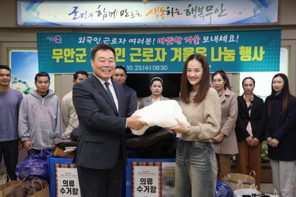 ▲외국인 근로자에게 겨울옷을 전달하는 김산 군수(사진제공=무안군)