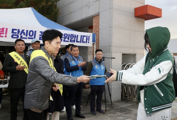 ▲김대중 전남교육감이 한 수험생에게 핫팩을 전하며 격려하고 있다.(사진제공=전라남도교육청)