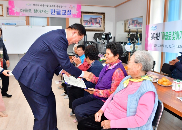 ▲김한종 장성군수가 '마을로 찾아가는 한글교실' 수료증을 어르신께 전달하고 있다.(사진제공=장성군)