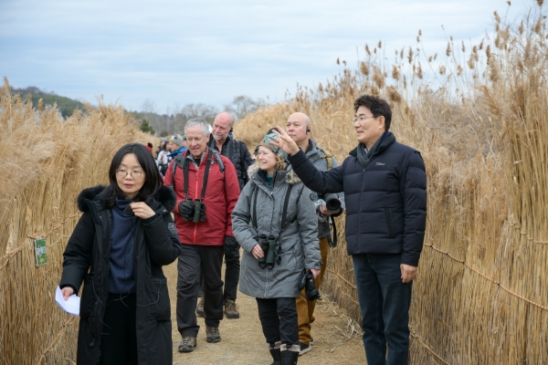 ▲노관규 순천시장이 순천만습지를 방문한 국제두루미재단 임원들에게 흑두루미 서식지를 안내하고 있다.(사진제공=순천시)