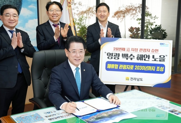 ▲김영록 전라남도지사가 13일 오전 도청 집무실에서 민선 7, 8기 최초로 ‘영광 백수해안 노을 관광지’를 도 관광지로 지정하는 결재를 하고 있다.(사진제공=전라남도)