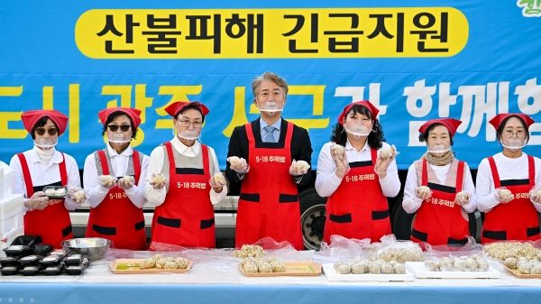 ▲김이강 광주 서구청장과 ‘양동 장금이’ 회원들이 31일 서구청 교통과 주차장에서 산불 피해를 입은 경북 영덕군 주민들에게 전달할 나눔과 연대의 상징인 5‧18주먹밥을 만들고 있다.(사진제공=광주 서구)
