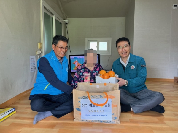 ▲장수 어르신께 선물꾸러미 전달하고 있는 현경면 지역사회보장협의체(사진제공=무안군)